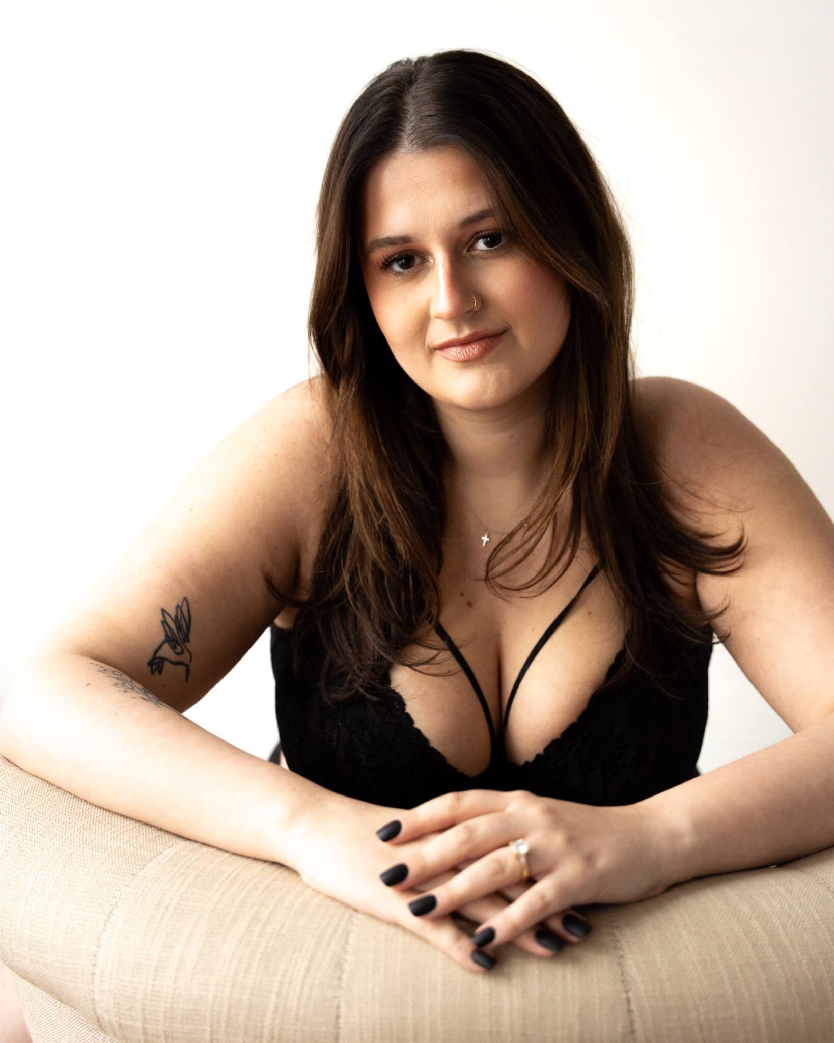 Woman in black lingerie seated for an intimate studio portrait