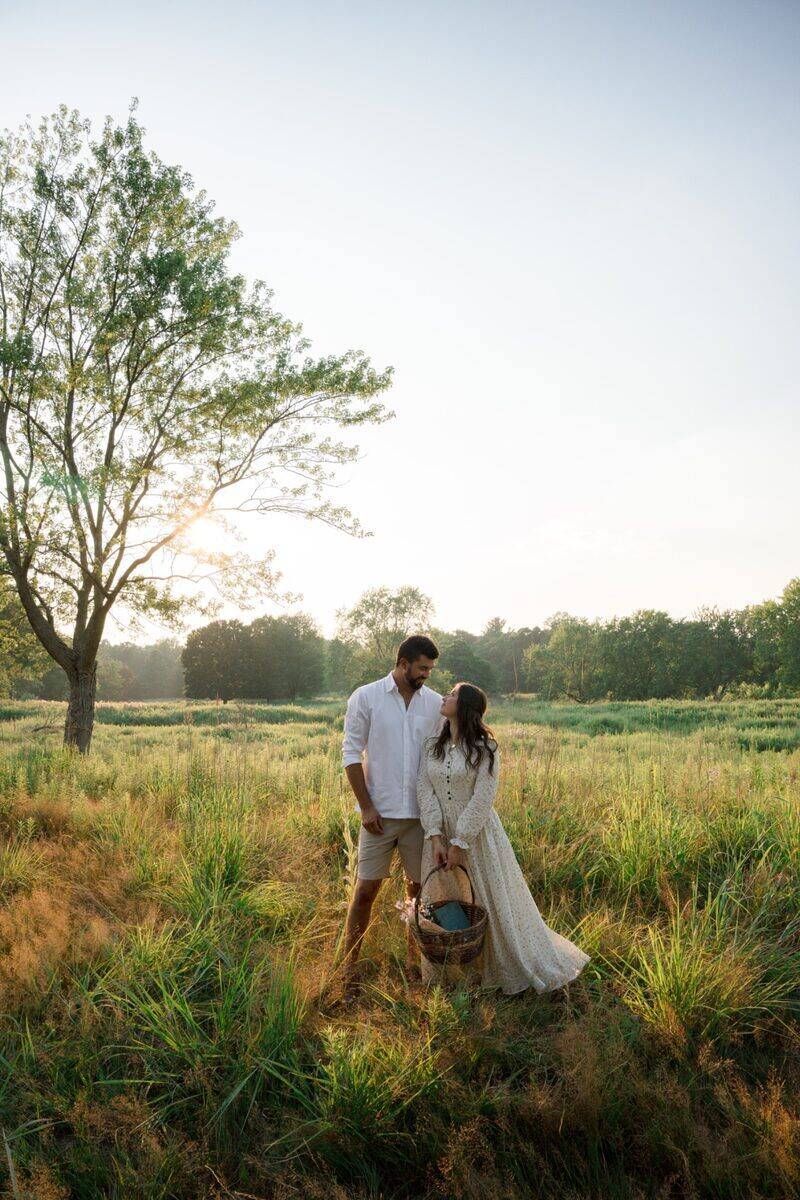 Newlyweds walking through a sunlit field
