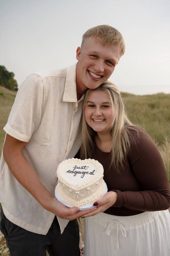 Engaged couple holding a celebration sign