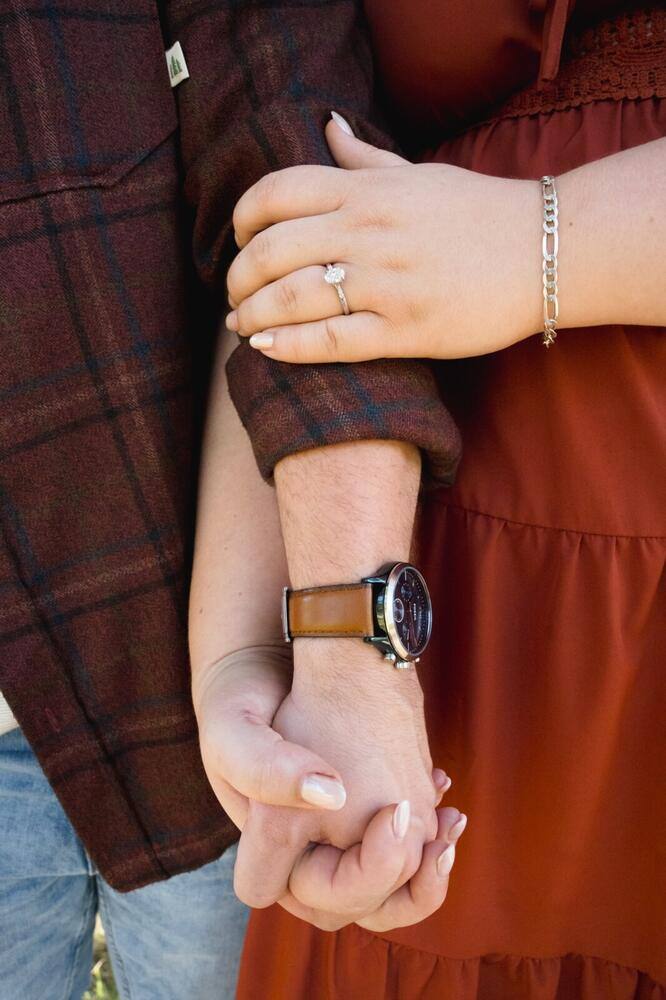 Newly engaged couple holding hands