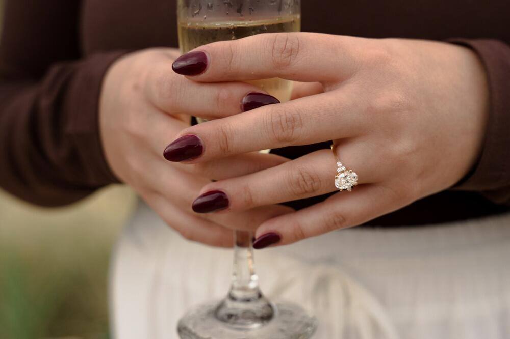 Engagement ring beside a champagne glass