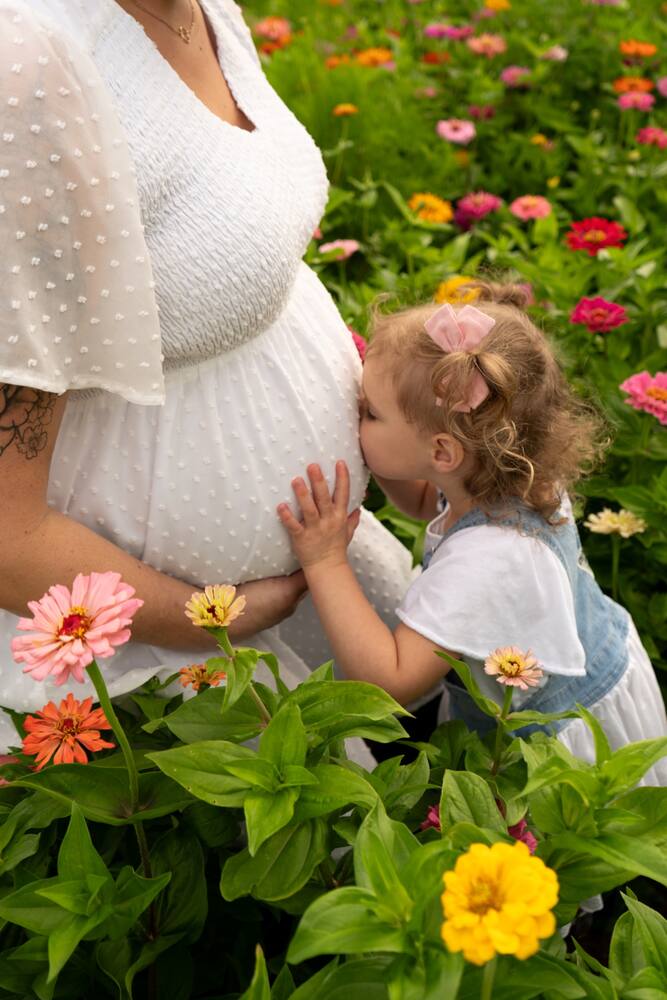 Young child cuddling her expecting mother