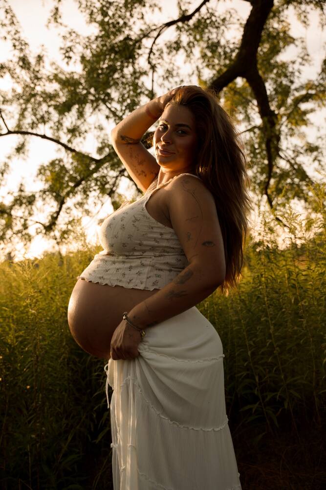 Outdoor maternity portrait in a white dress
