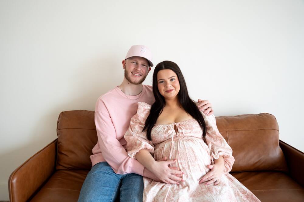 Expecting couple seated on a couch