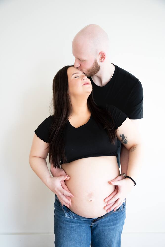 Expecting couple standing together in the studio