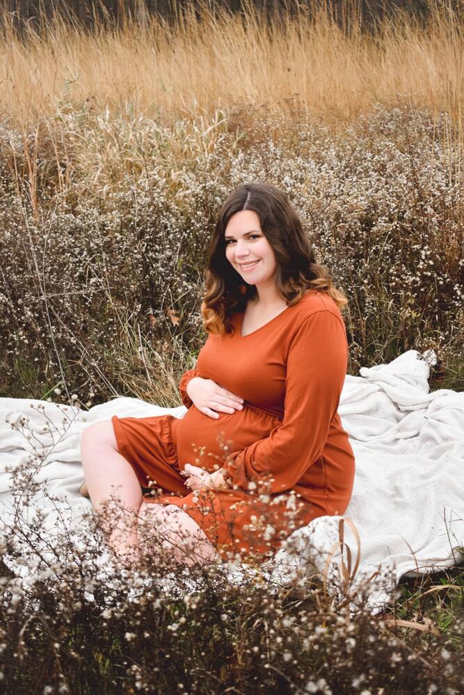Expecting mother seated in a wildflower field