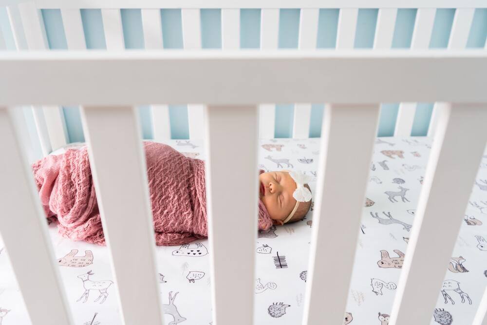 Newborn resting in a crib