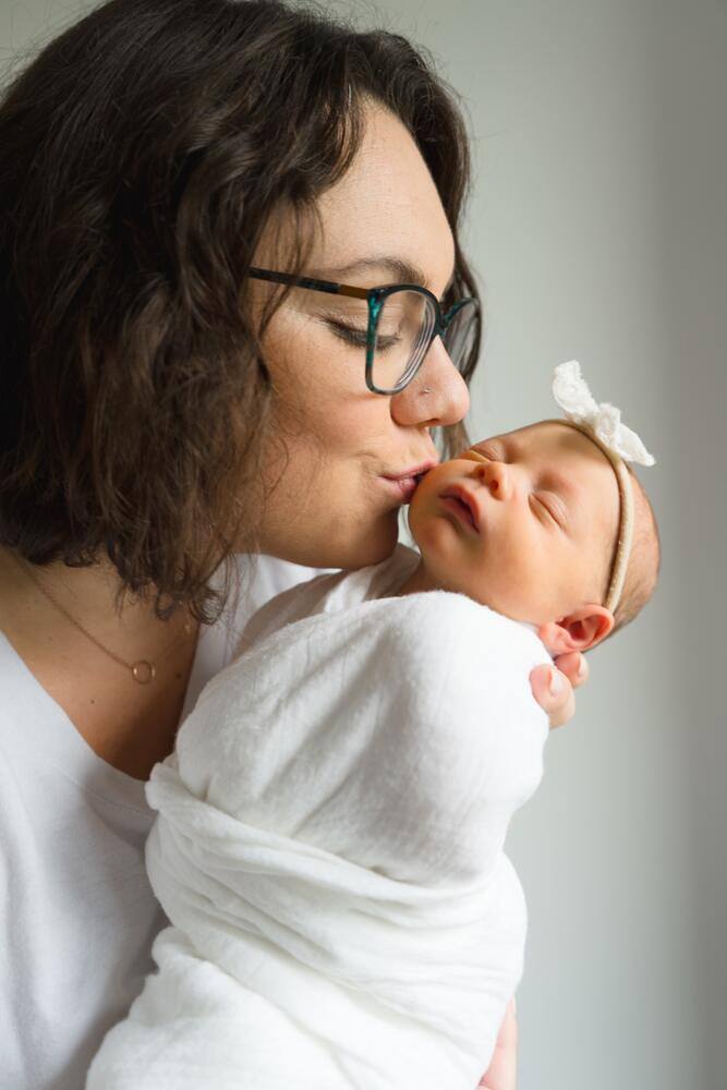 Mother kissing her newborn