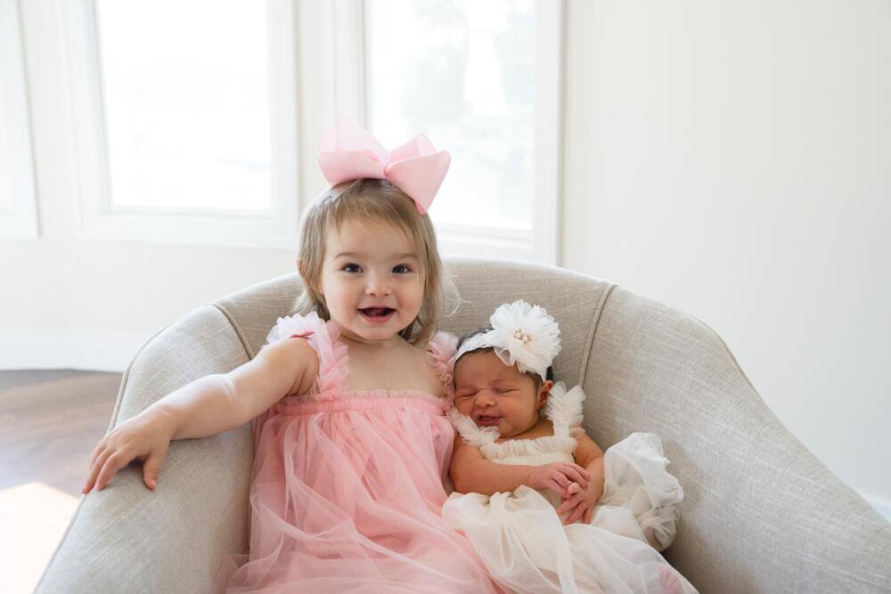 Big sister sitting beside the new baby