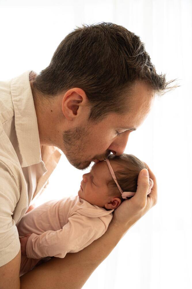 Father gently holding his newborn