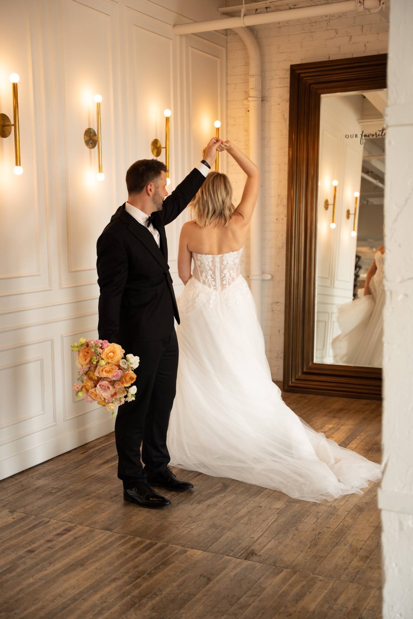 Newlyweds dancing together in a light-filled room