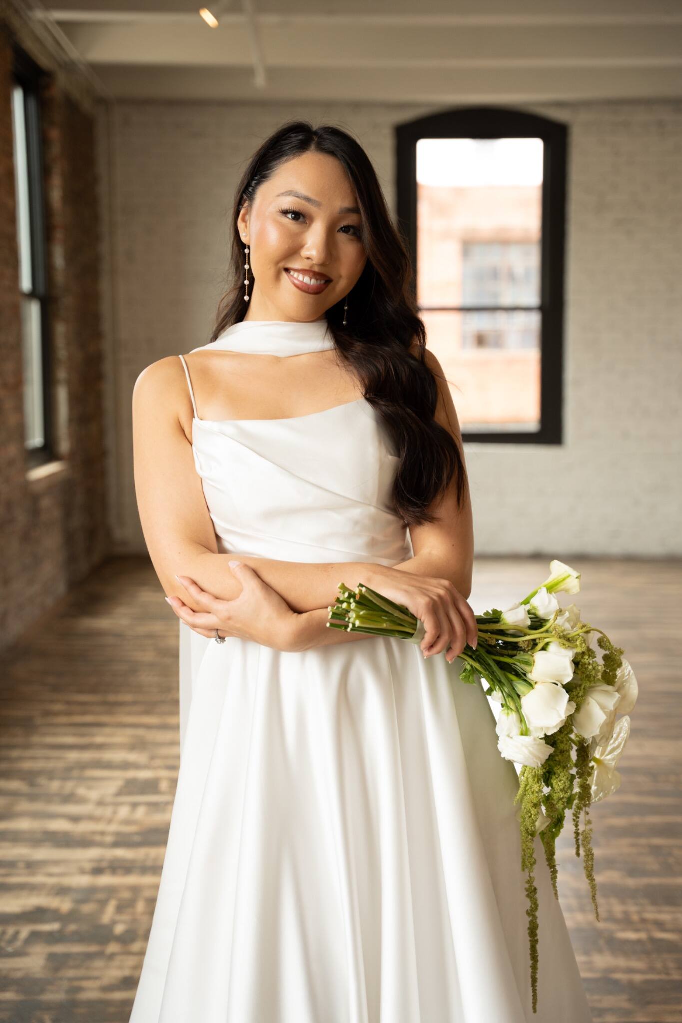 A bride standing beside a tall window