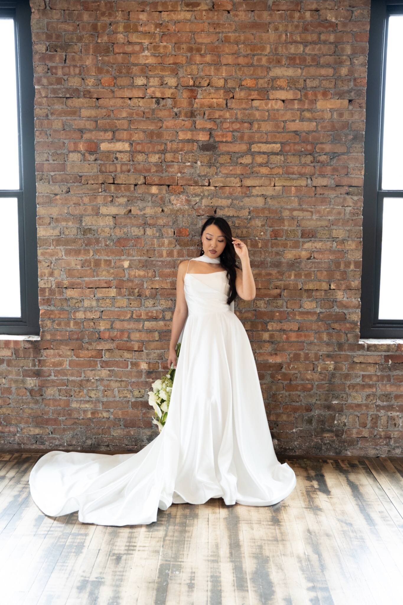 A bride standing against a warm brick wall