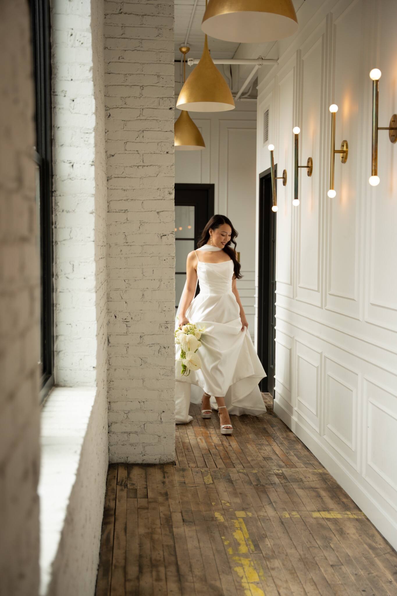 A bride walking through a sunlit corridor