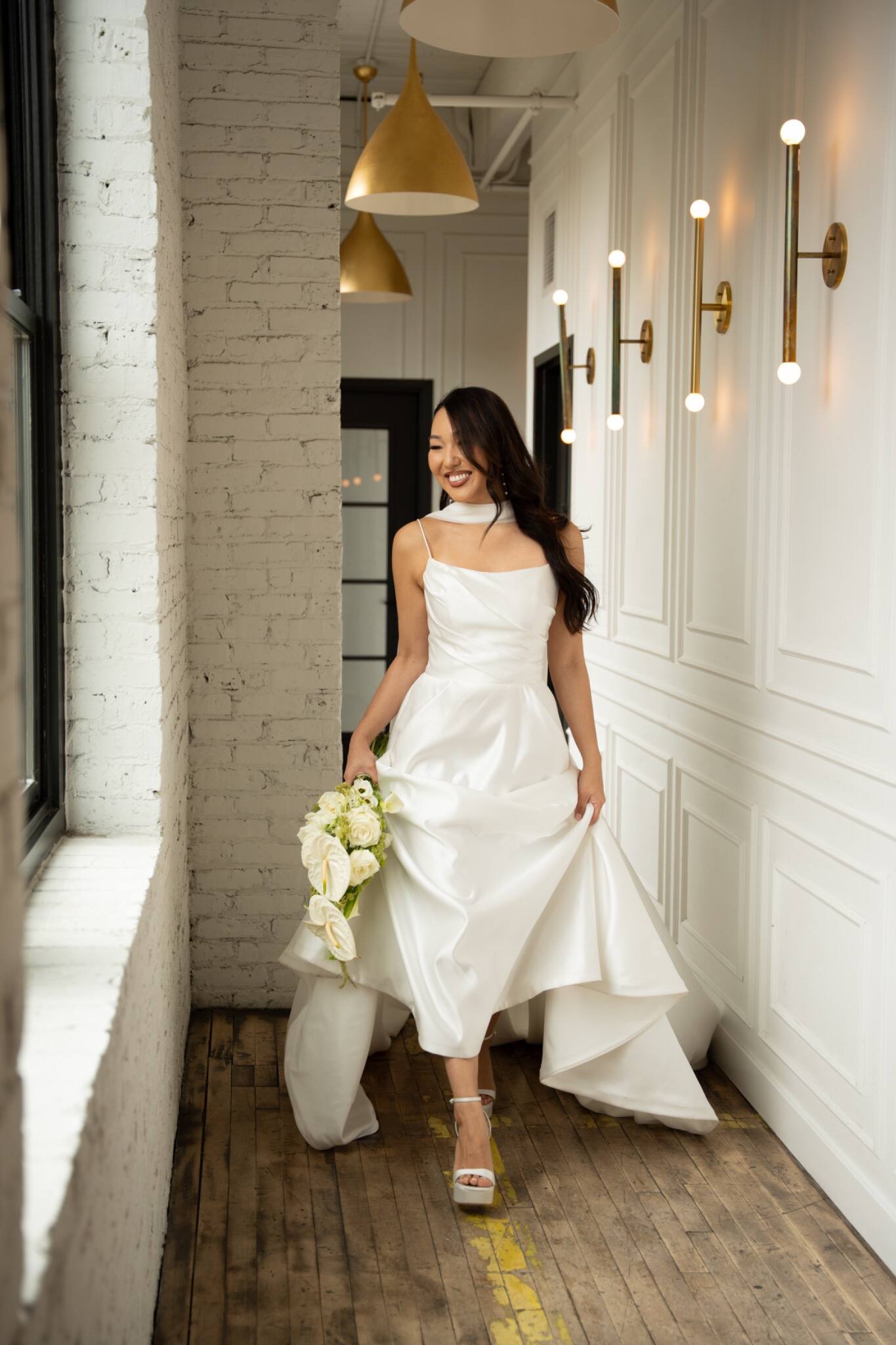 Bride walking toward the camera in a bright corridor