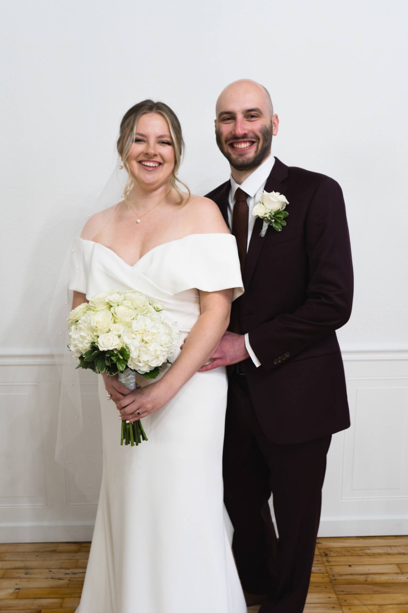 Classic newlywed portrait against a white wall