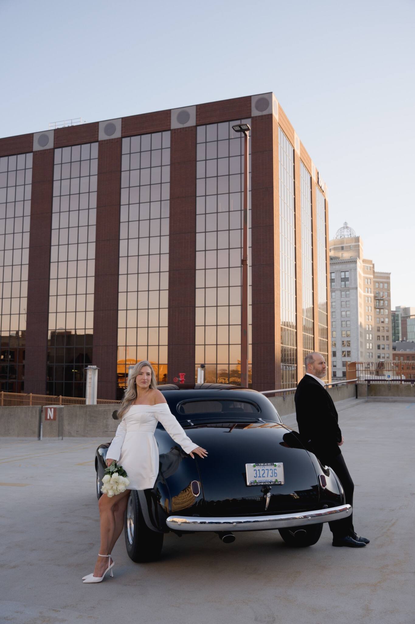 Wedding couple posing with a classic car in the city