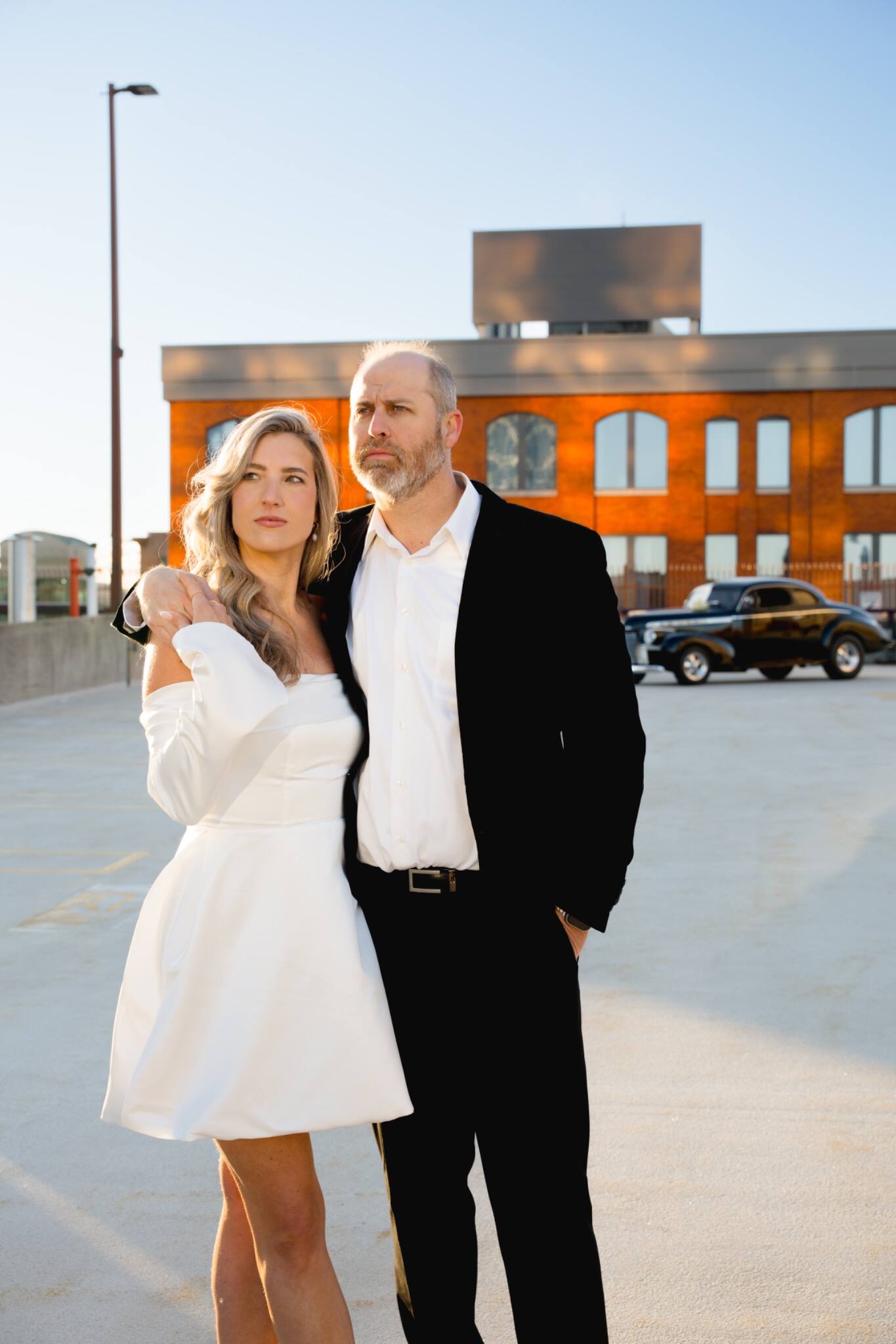A wedding couple posing together in warm evening light