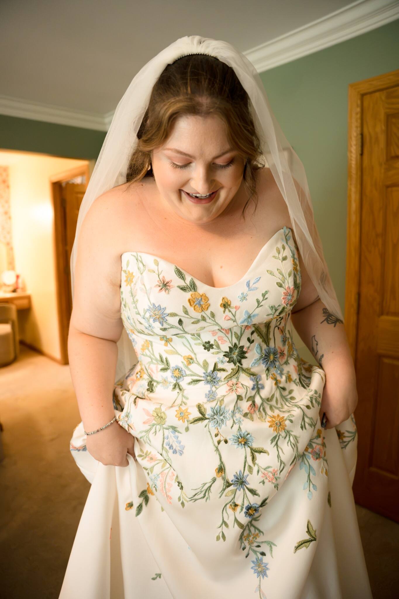 Bride smiling in her embroidered wedding dress