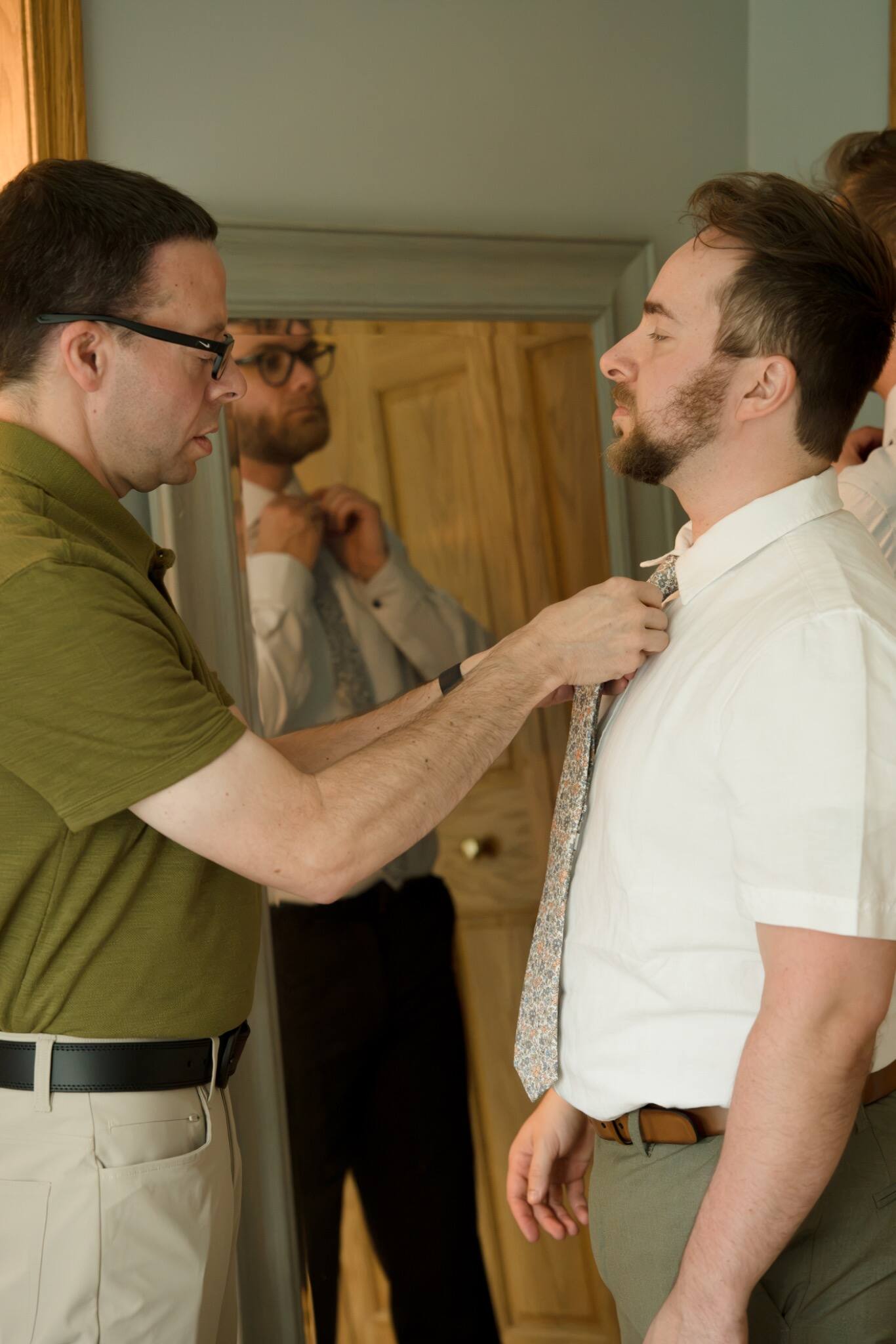 Family helping the groom prepare for his wedding