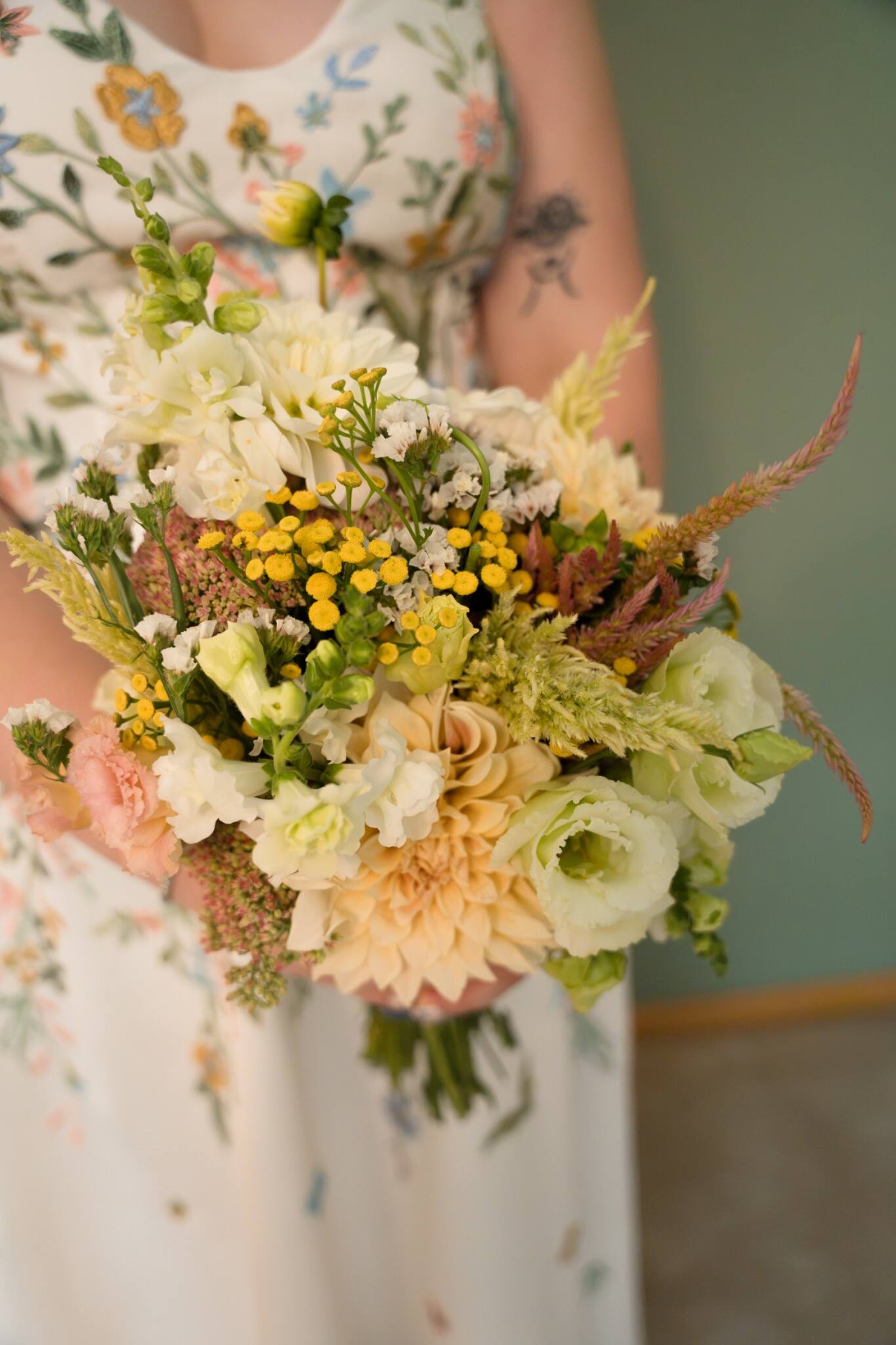 Wildflower bridal bouquet and embroidered dress detail