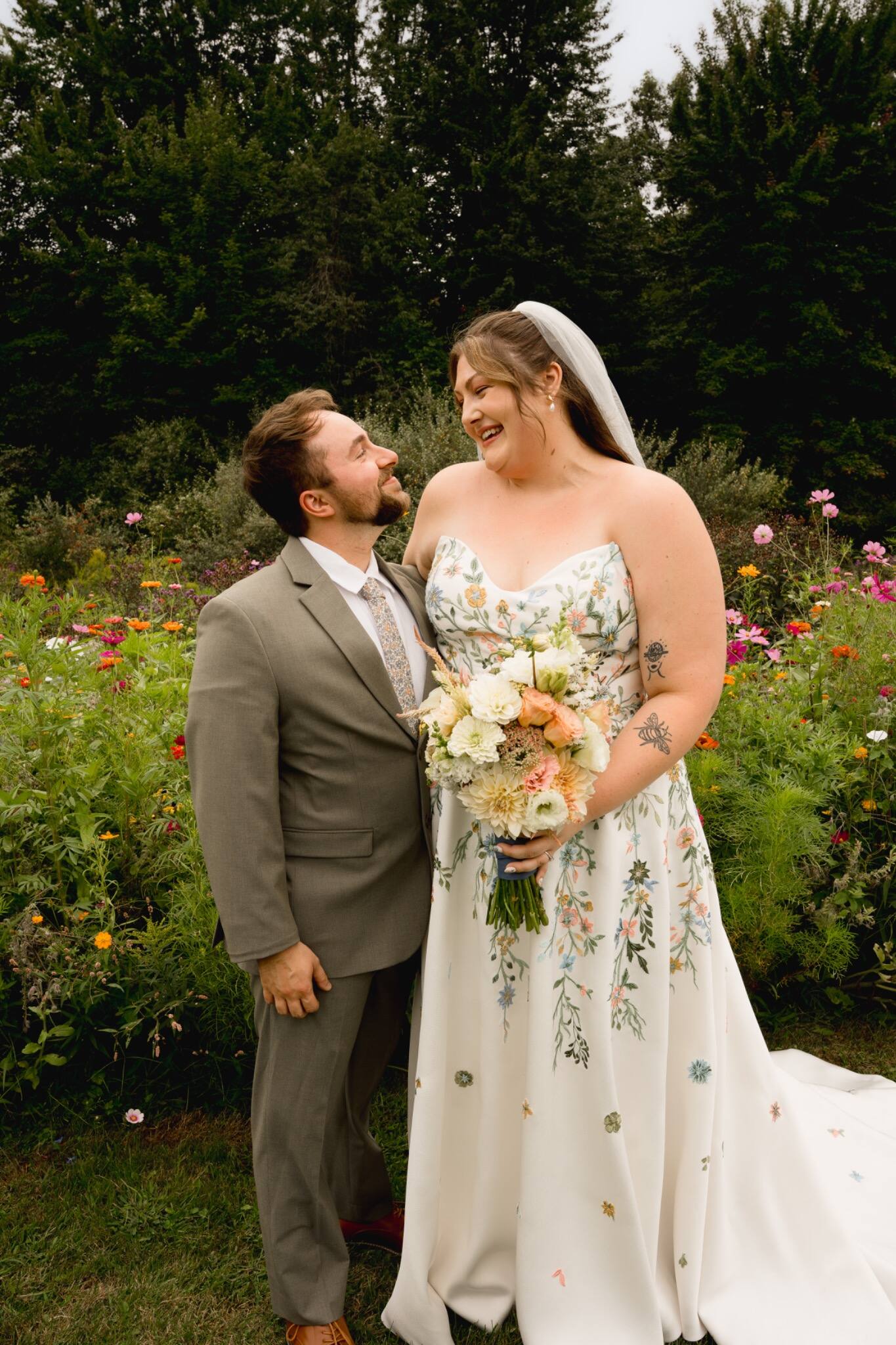Newlyweds laughing together in a garden portrait