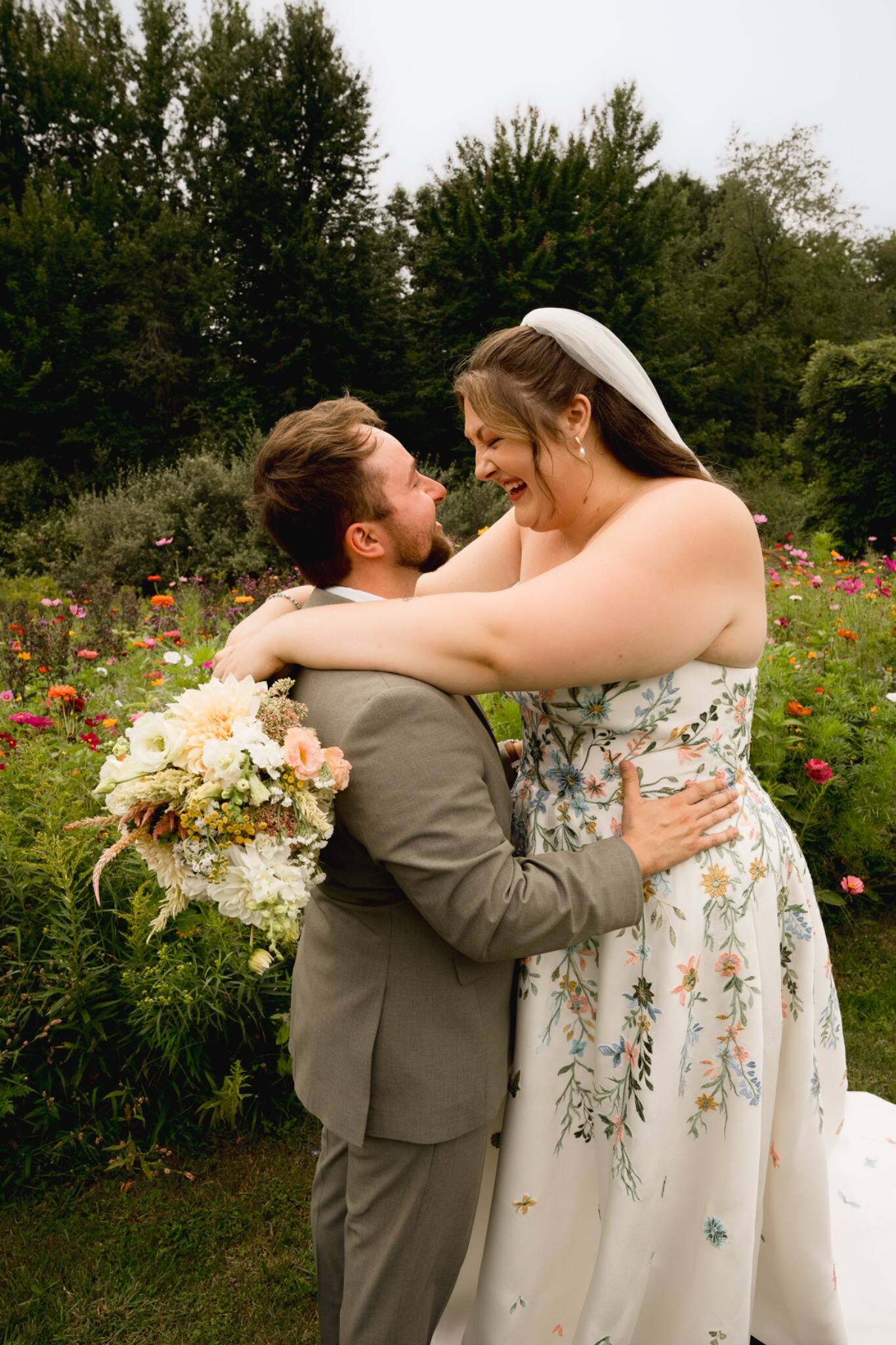 Newlyweds embracing in a colorful flower garden