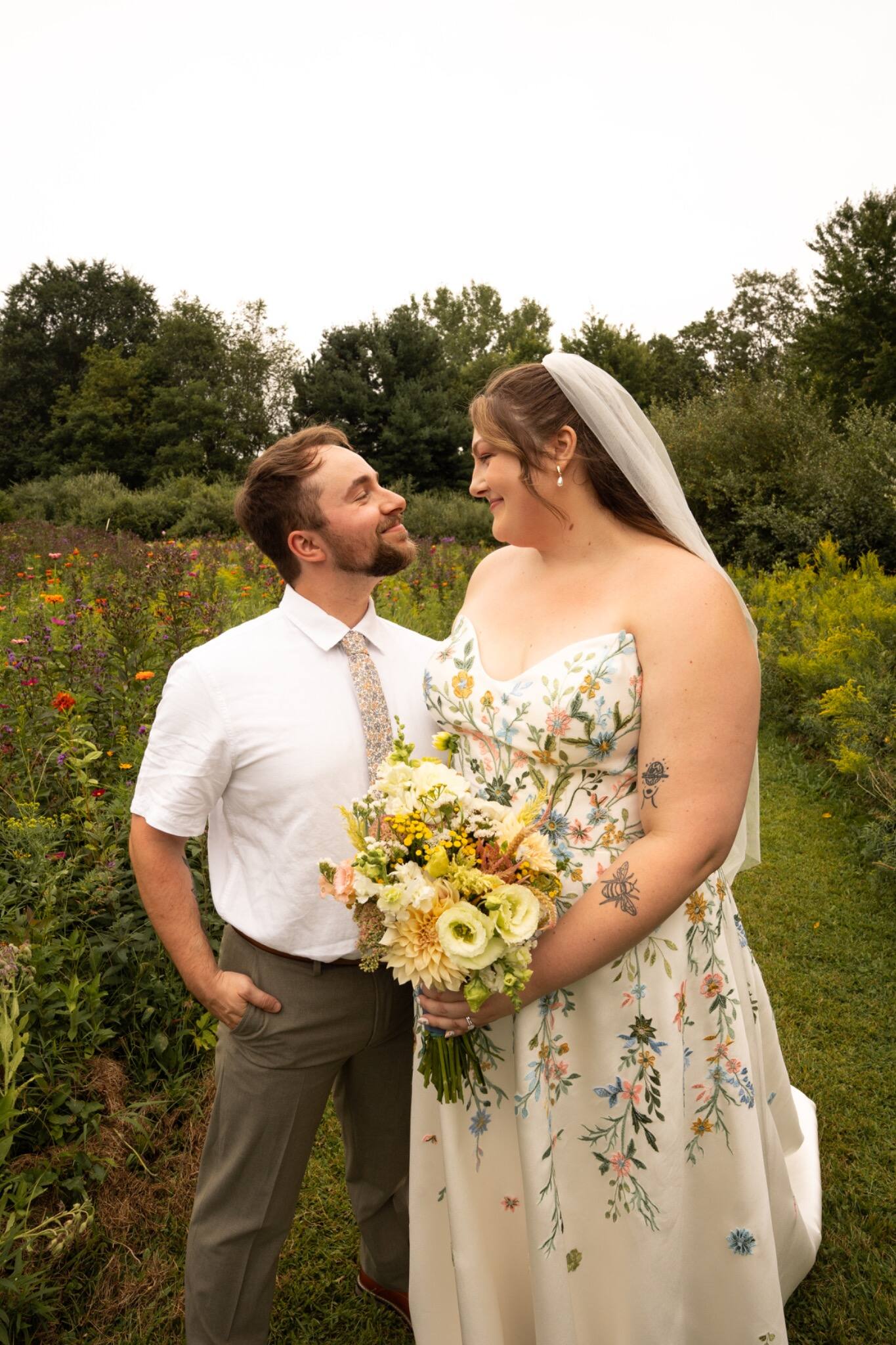 Bride and groom smiling together among garden flowers