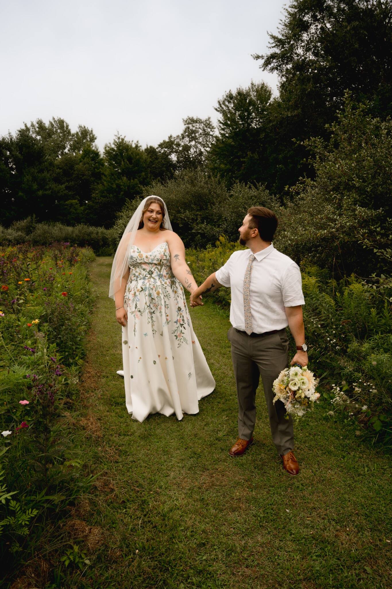 Bride and groom walking hand in hand through the garden