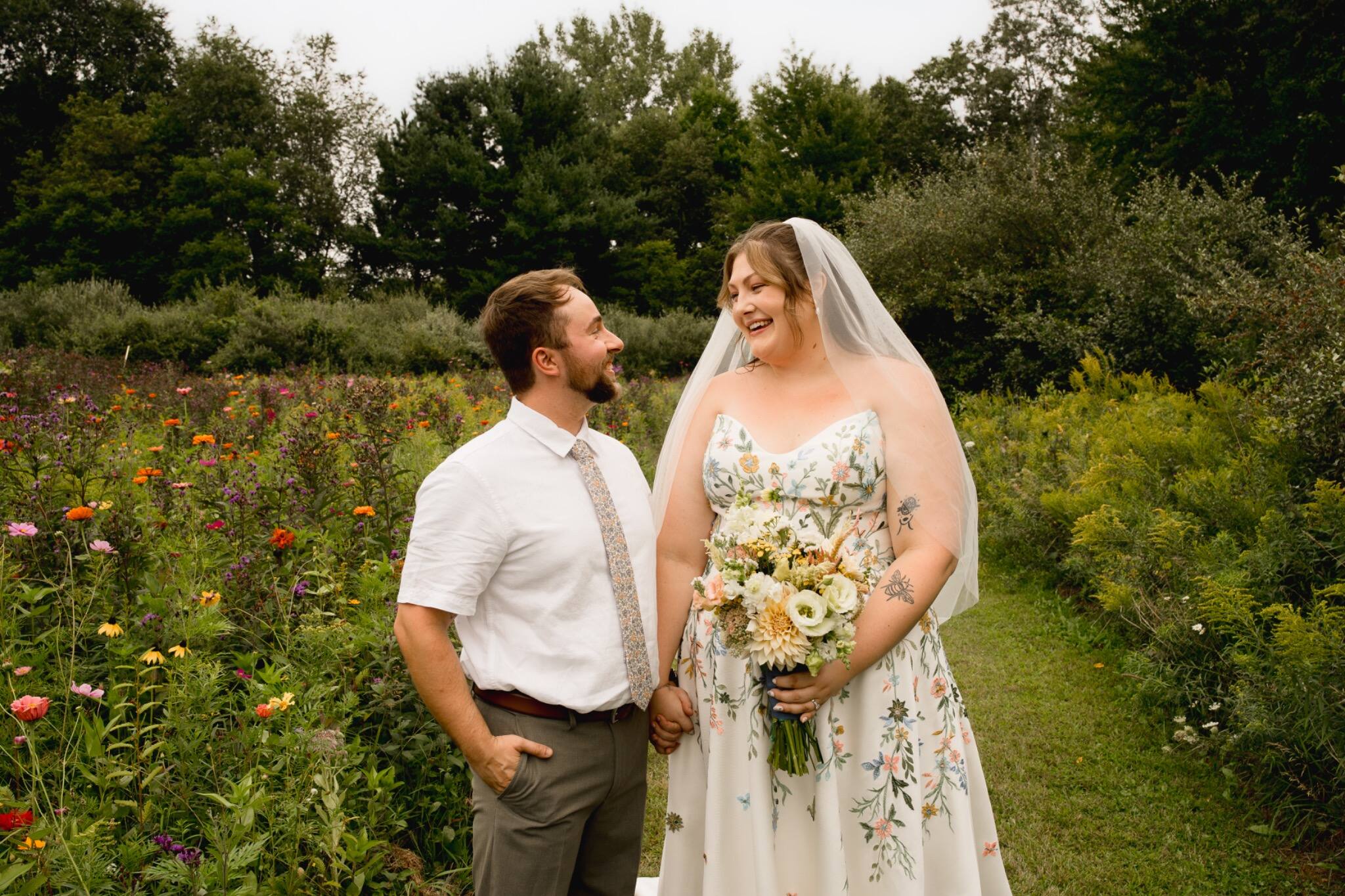 Bride and groom smiling at each other in the garden