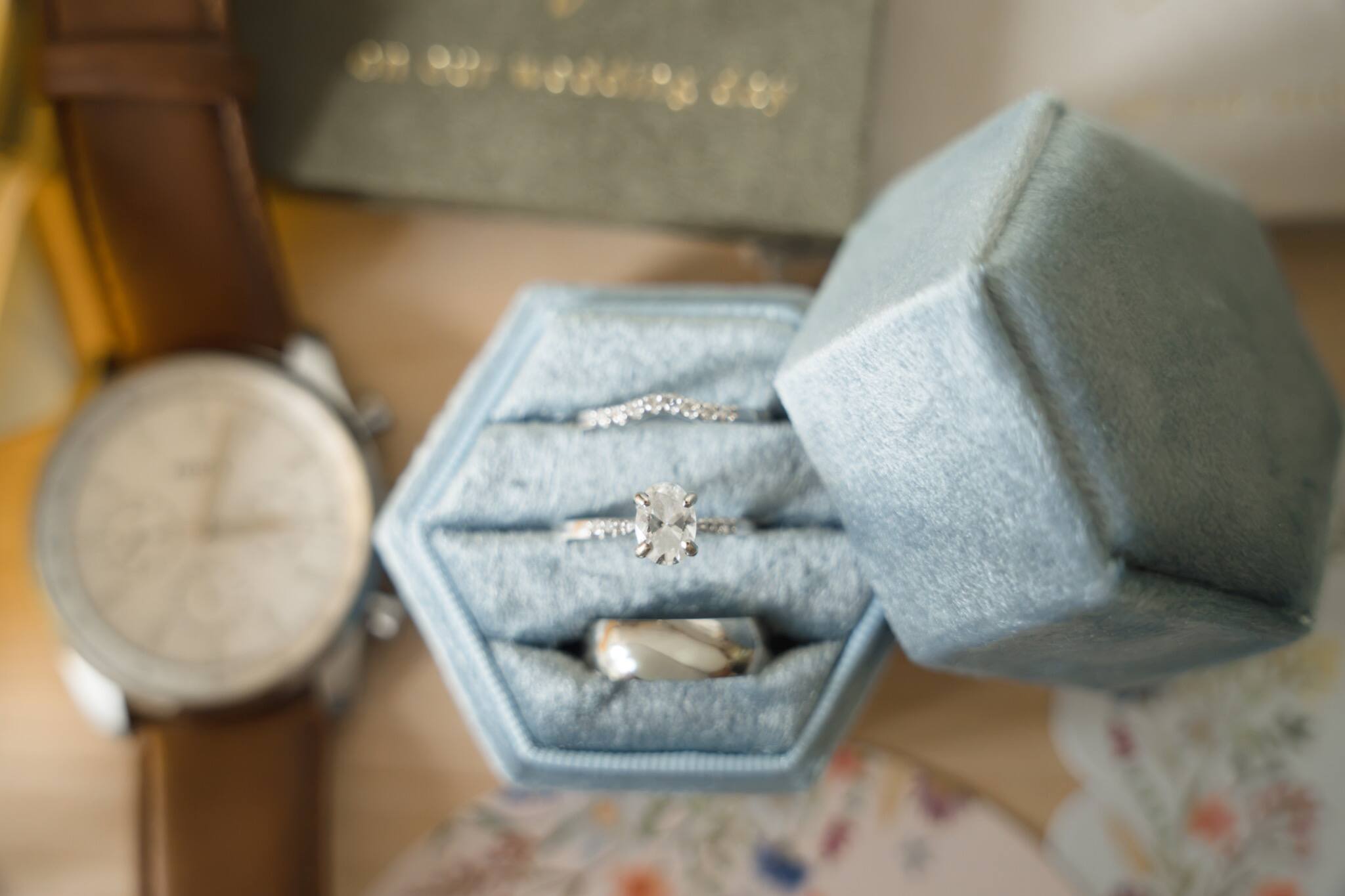 Wedding rings arranged beside a watch and ring boxes