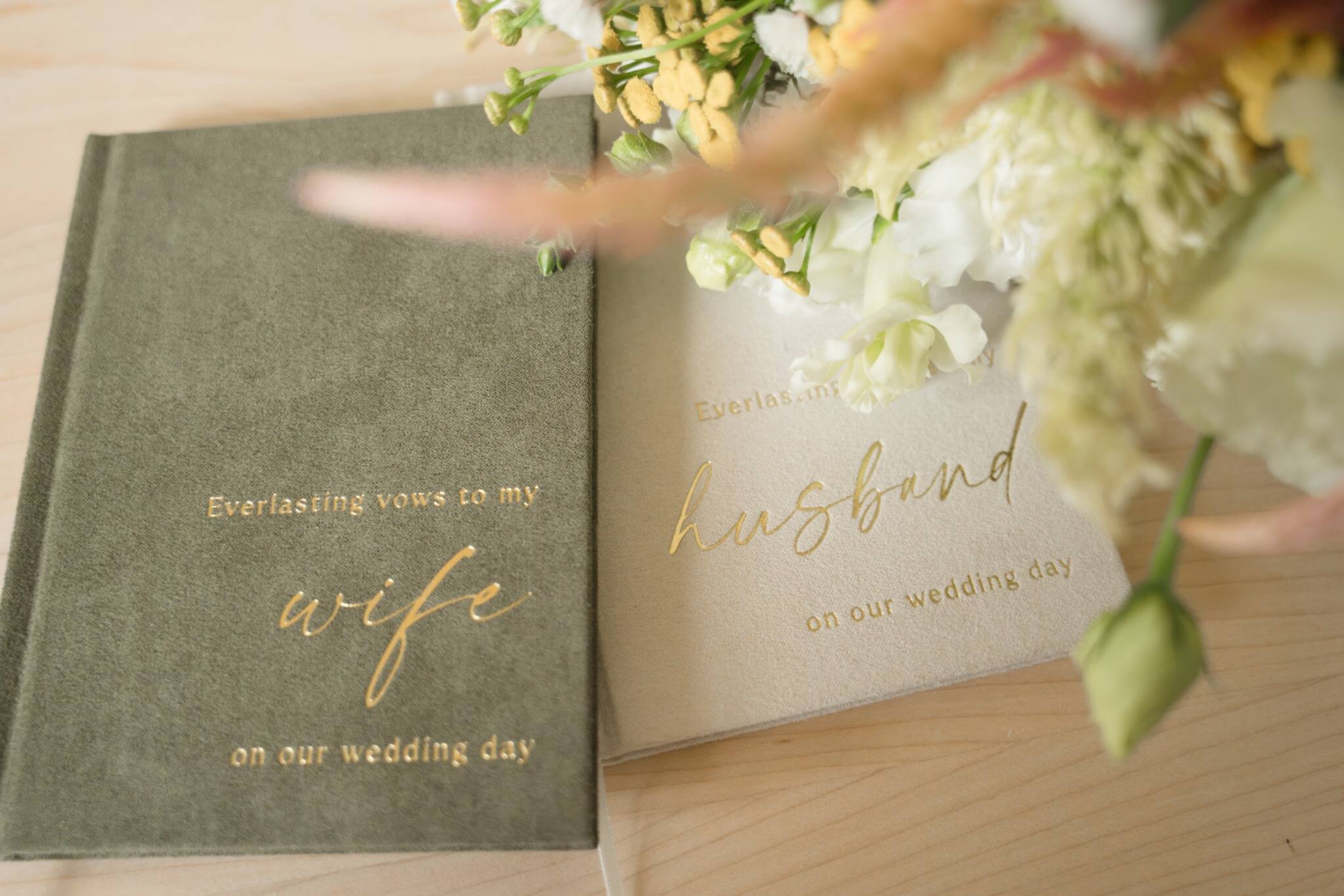 His and hers wedding vow books with flowers