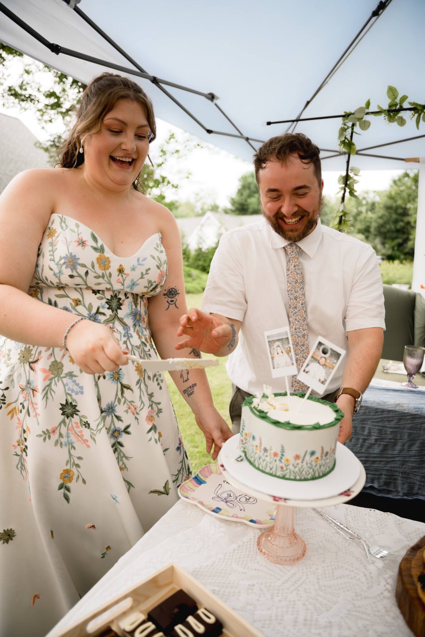 Newlyweds laughing together while cutting their cake
