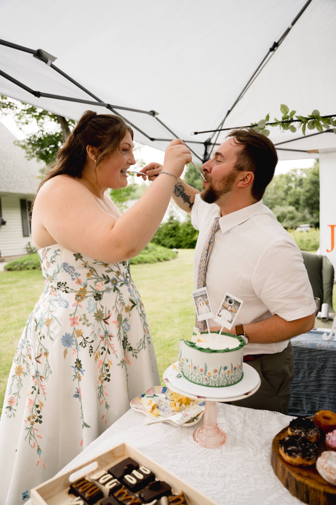 Bride and groom playfully sharing wedding cake