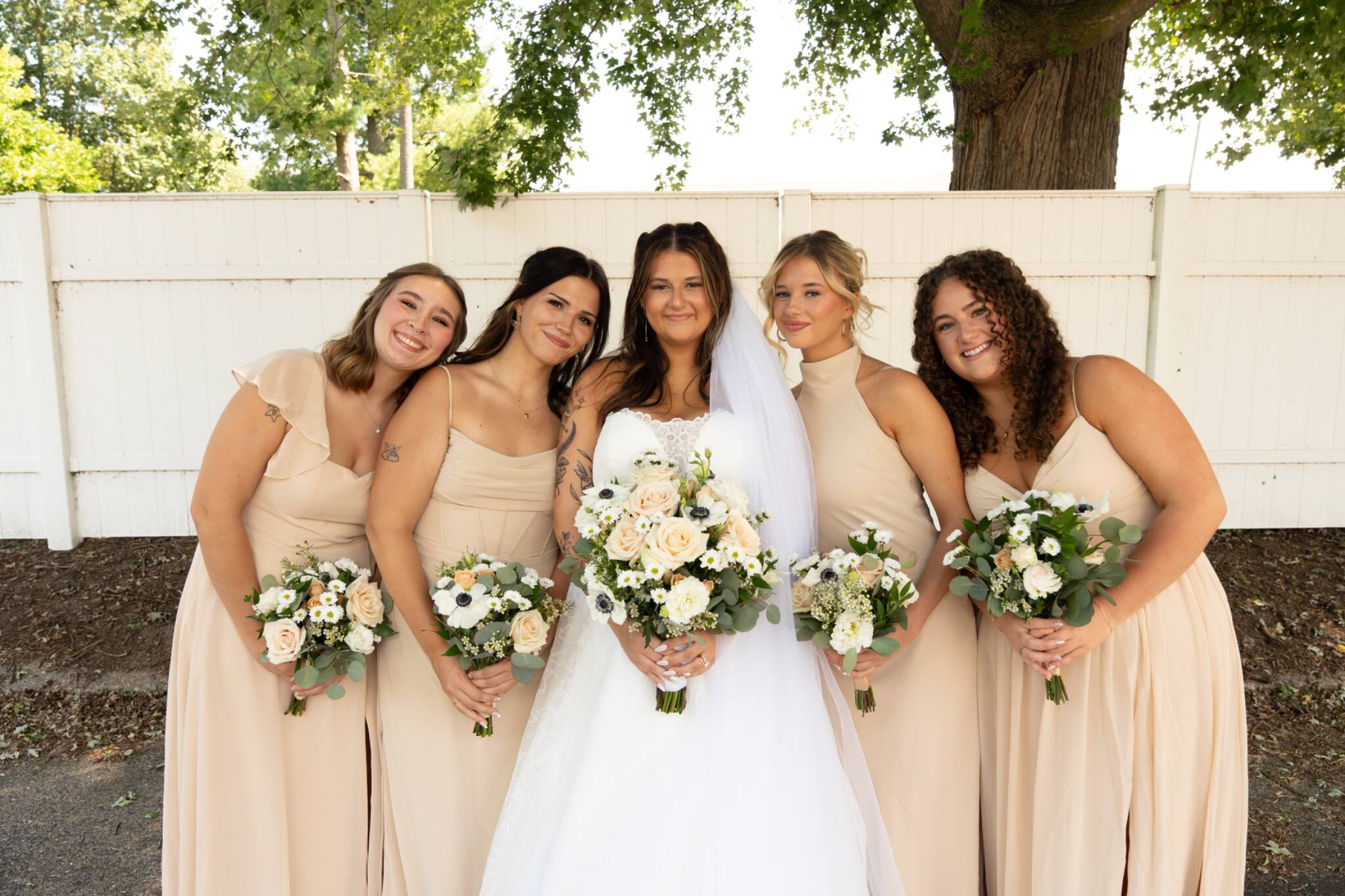 Bride sharing a joyful portrait with her bridesmaids