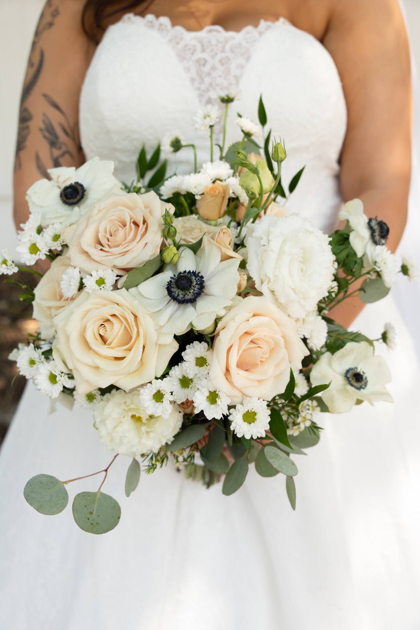 Bride holding a soft ivory and peach bouquet